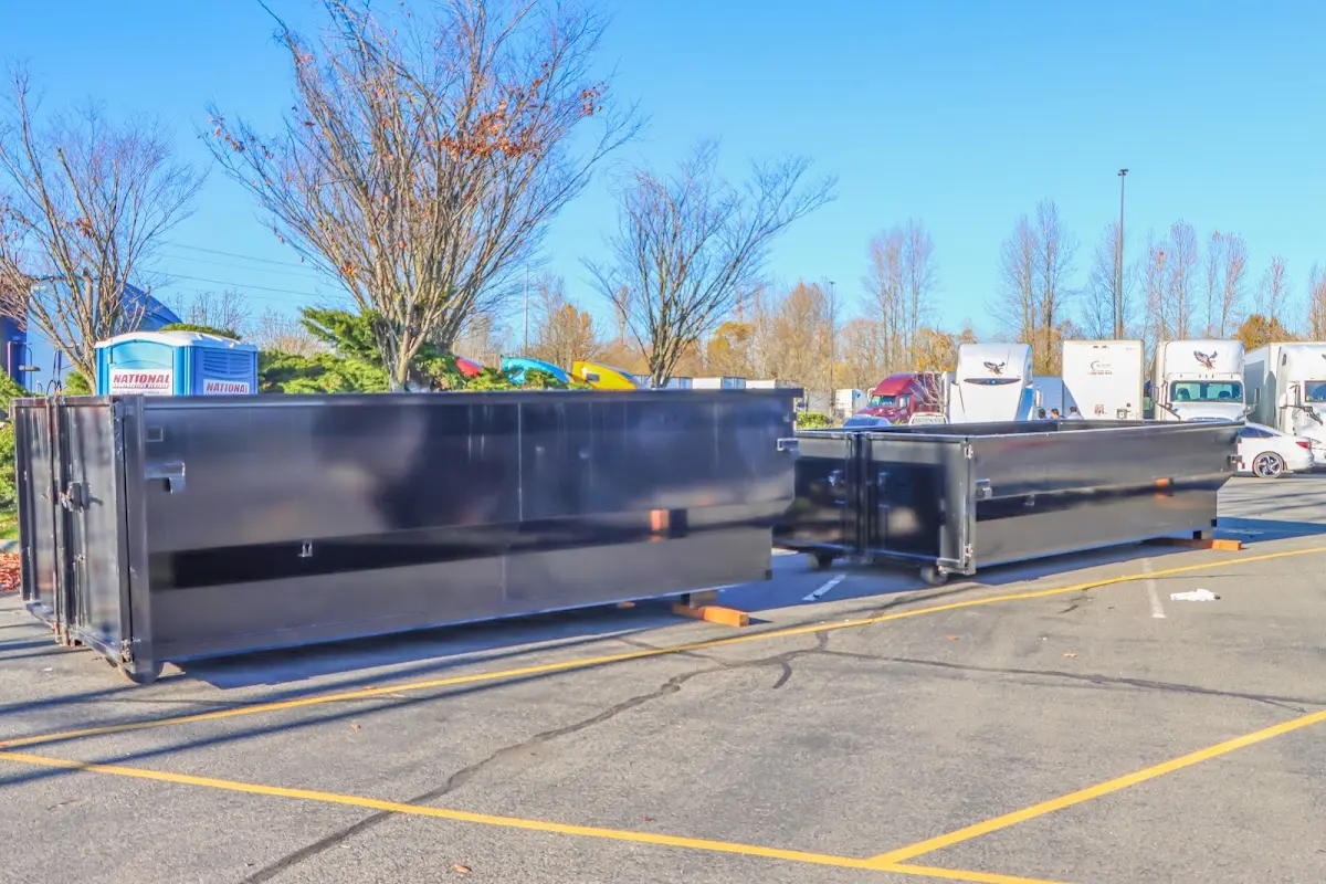 Professional dumpster rental service with roll-off container on residential driveway in West Bradford
